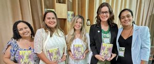 Na foto estão, da esquerda para a direita, Luciana Koury, Herena Melo,Tarcila Santos Britto Gomes, Cirlene Luiza Zimmermann e Andréia Mello no lançamento do livro durante a COP30. Foto: Divulgação/ABRAMPA